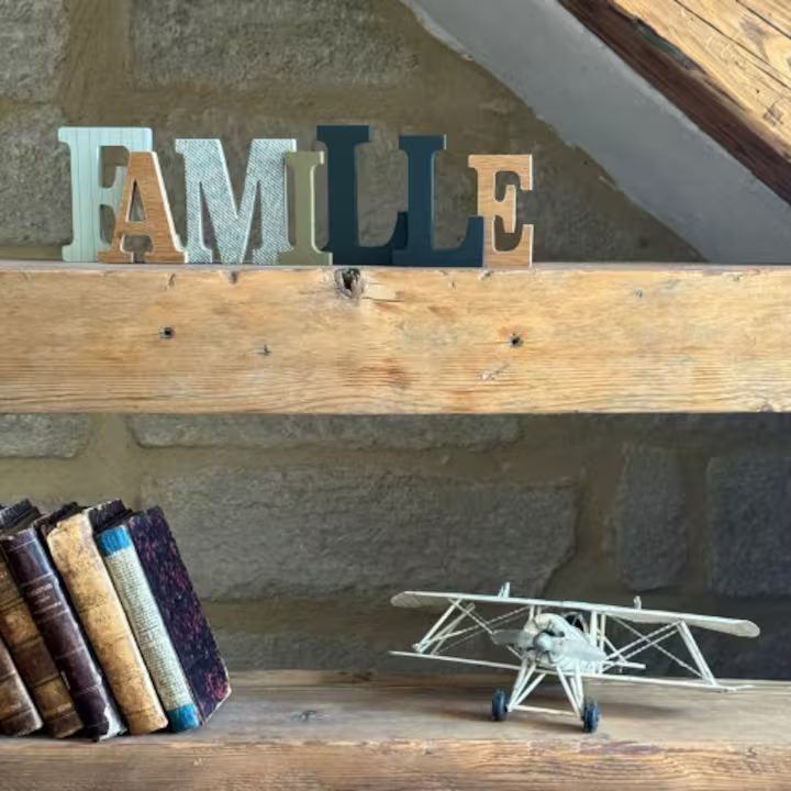 Étagère en bois du salon, lettres « Famille », vieux livres et avion miniature